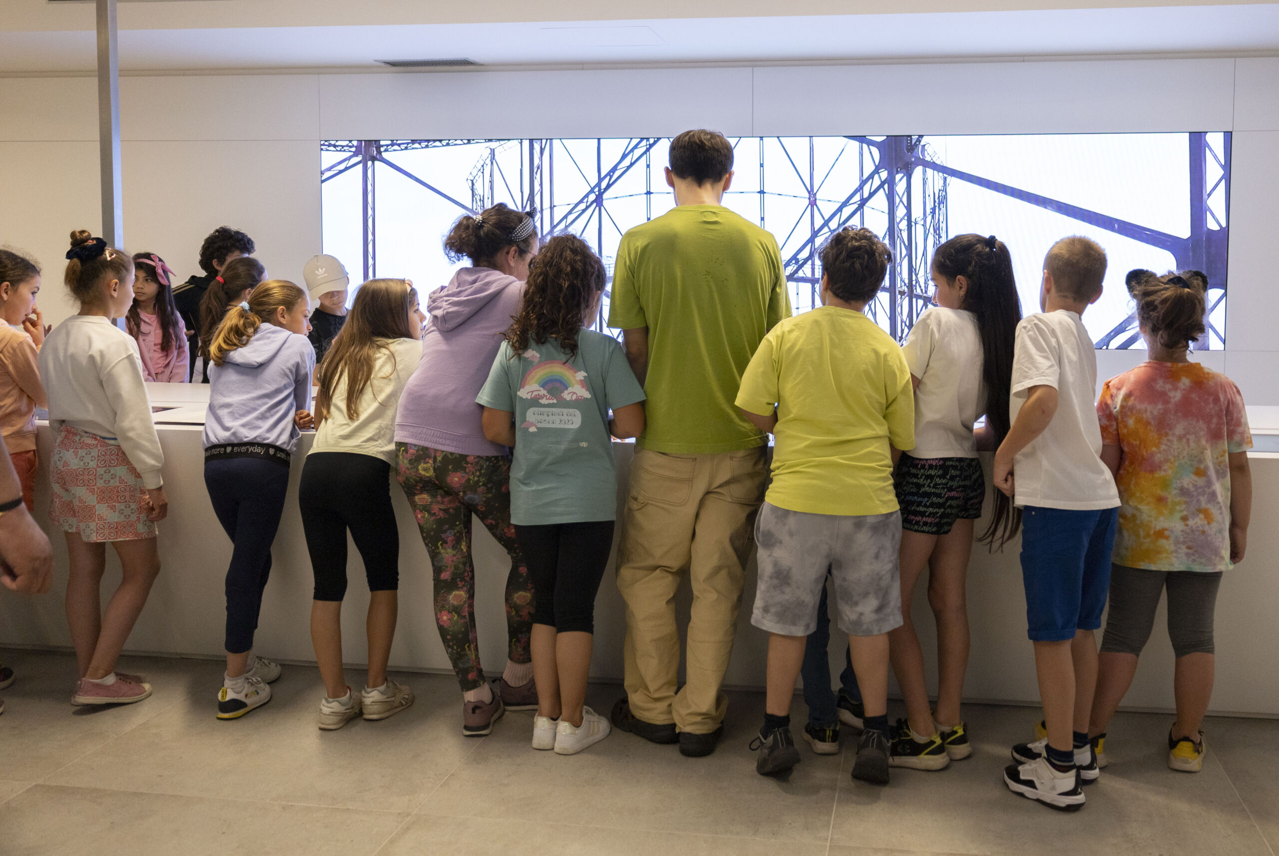 Bambini e bambine osservano un’installazione durante la visita al museo Italgas per l’evento Capsule del Tempo “Backwards”